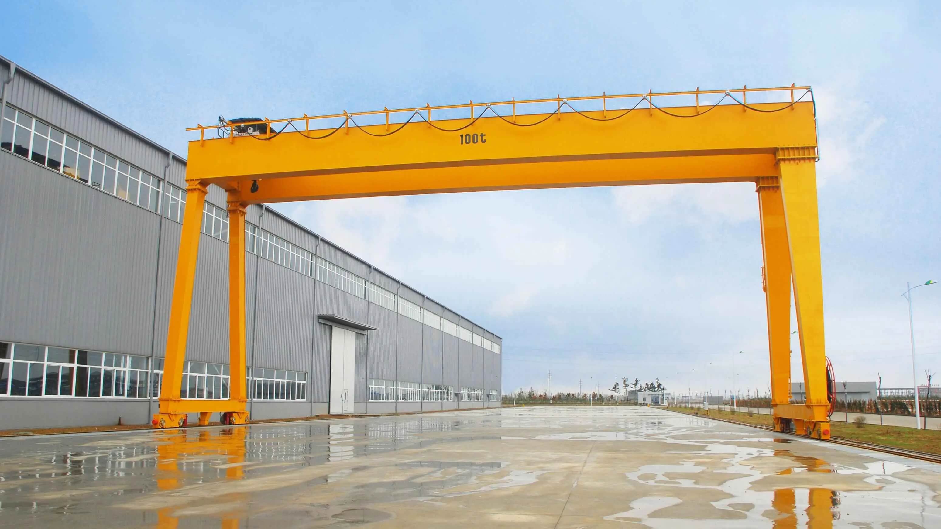 Yellow gantry crane with double girder, in front of a building